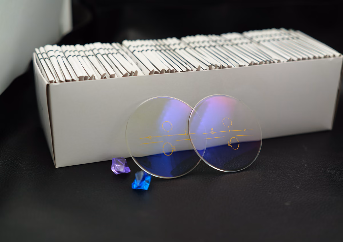 Full progressive lens pair with multifocal markings in front of stock lens box